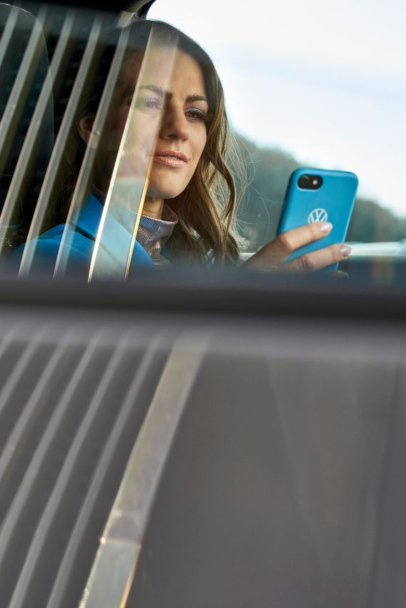 Frau schaut auf ein Handy im Auto