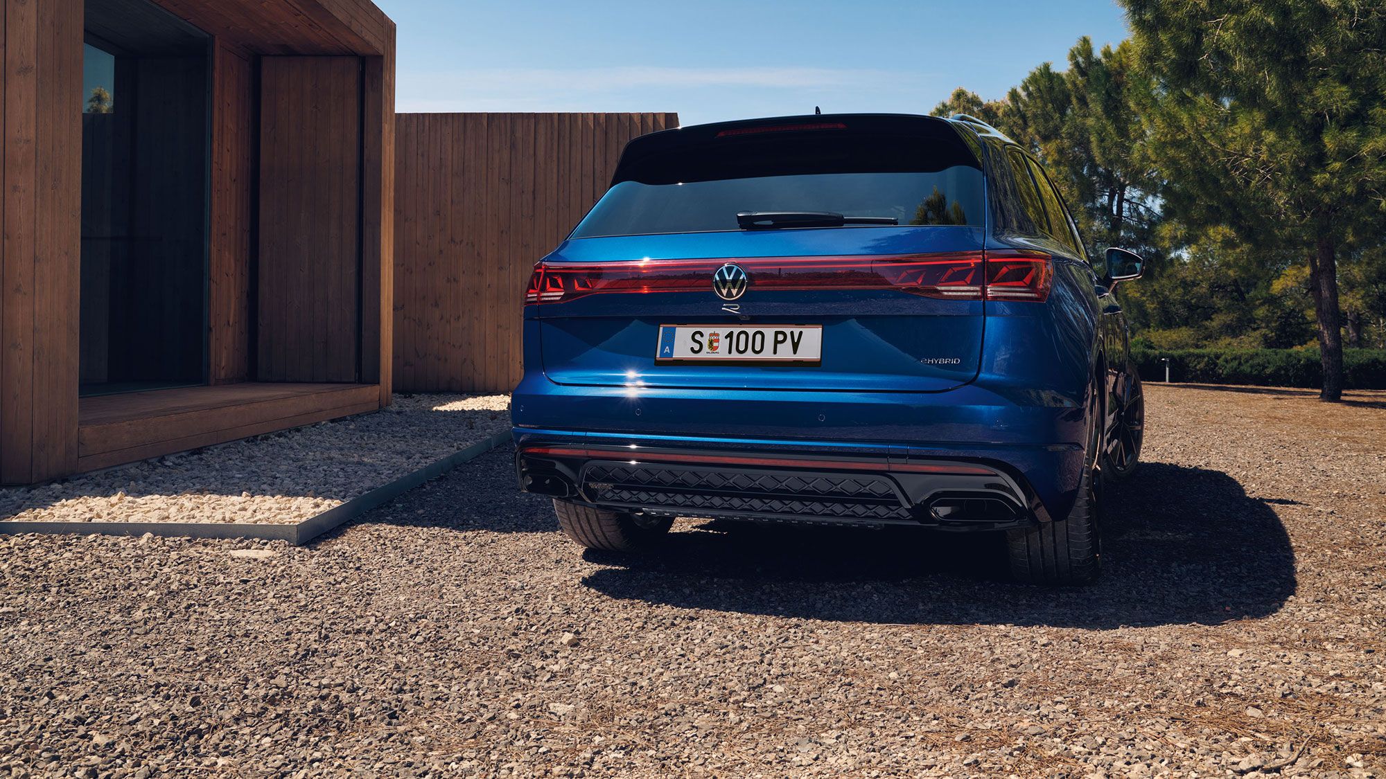 Heckansicht des VW Touareg R eHybrid, der vor einem Haus parkt