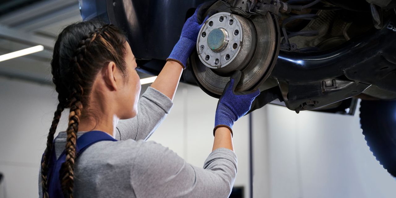 VW Mechanikerin beim Bremsenservice