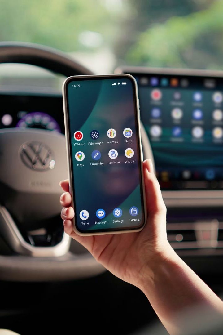 Frau sitzt auf dem Fahrersitz und spiegelt Smartphone per App Connect auf dem Fahrzeugdisplay