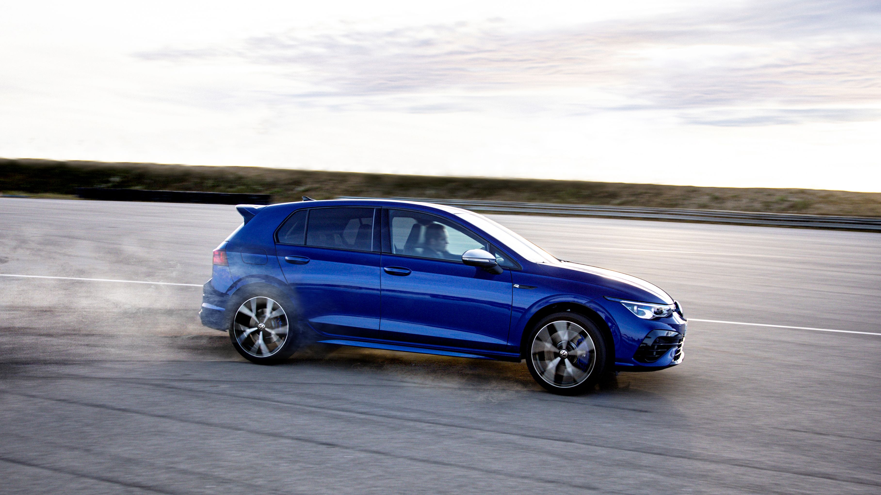 Ein blauer VW Golf R fährt auf einer Rennstrecke