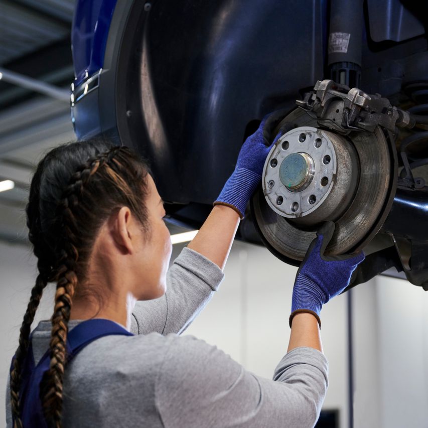 VW Mechanikerin beim Bremsenservice