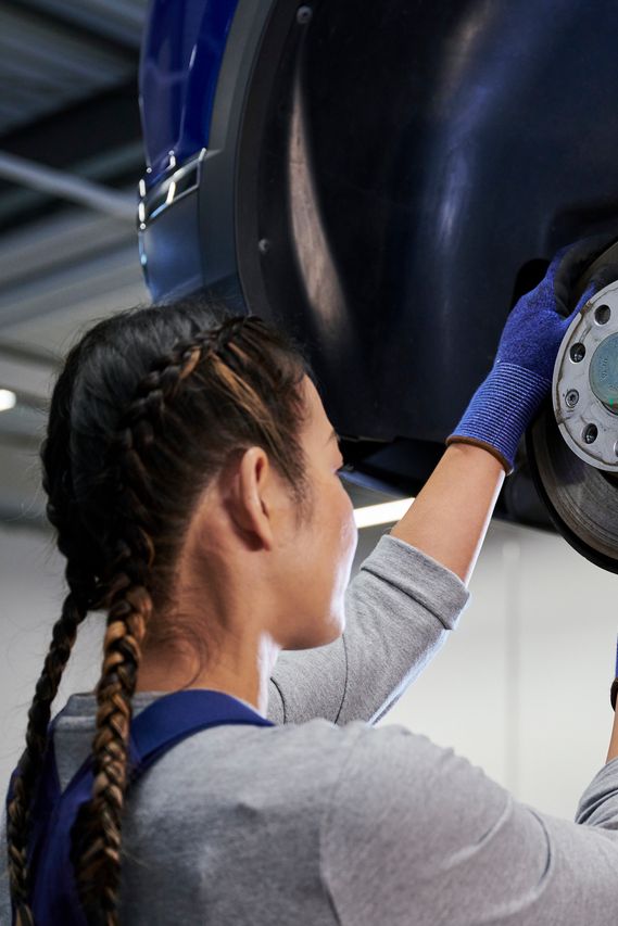 VW Mechanikerin beim Bremsenservice