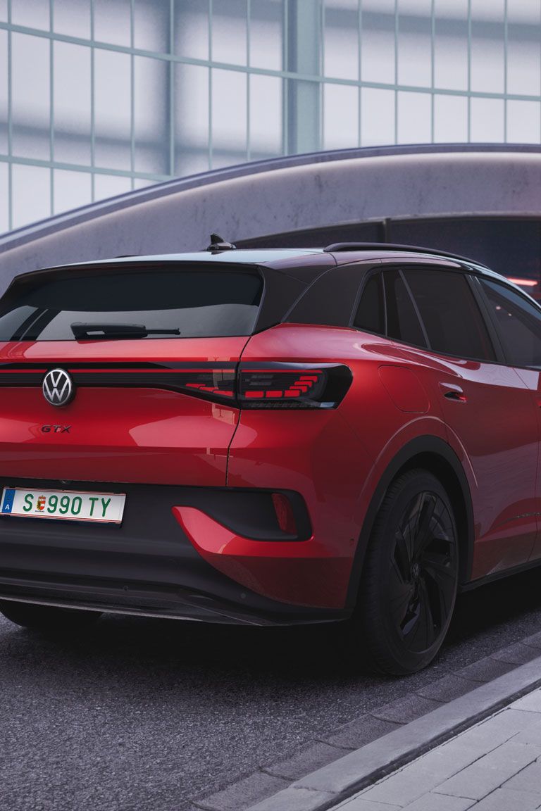 Ein roter ID.4 GTX steht am Straßenrand neben einer Ladesäule