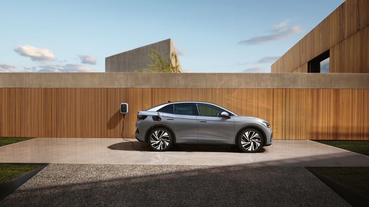 Seitenansicht eines grauen VW ID.5, der an einer Wallbox aufgeladen wird. 