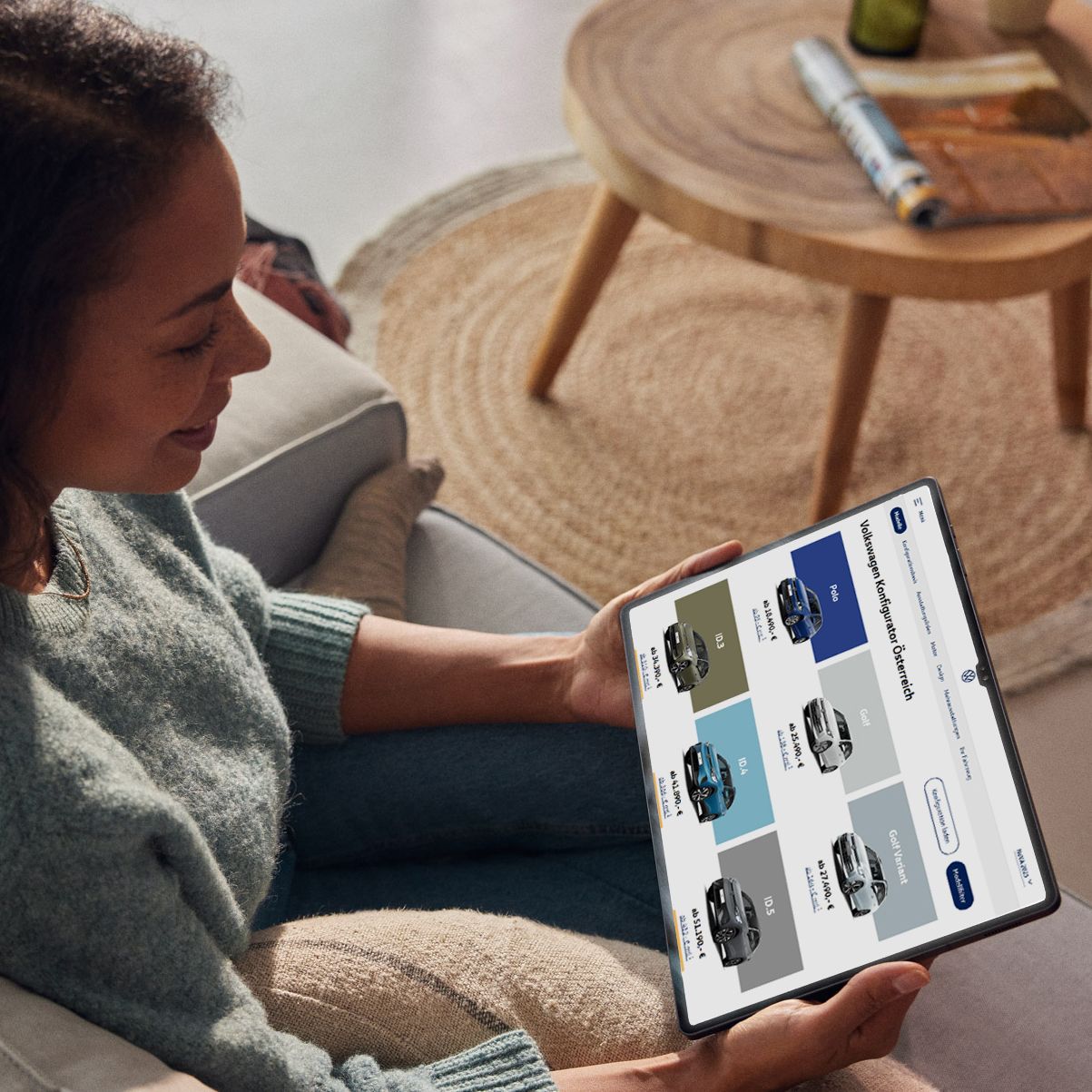 Eine Frau sieht sich die aktuellen VW Modelle auf ihrem Tablet an