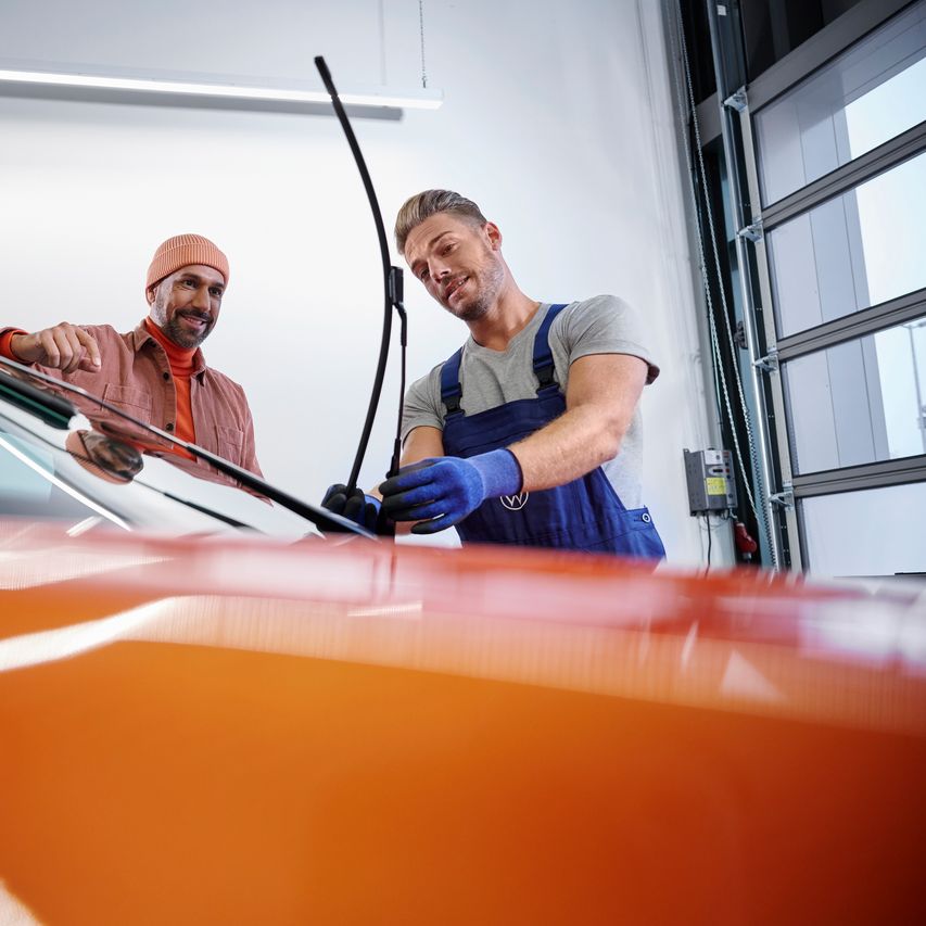 Ein VW Service Techniker wechselt Wischerblätter bei einem Volkswagen