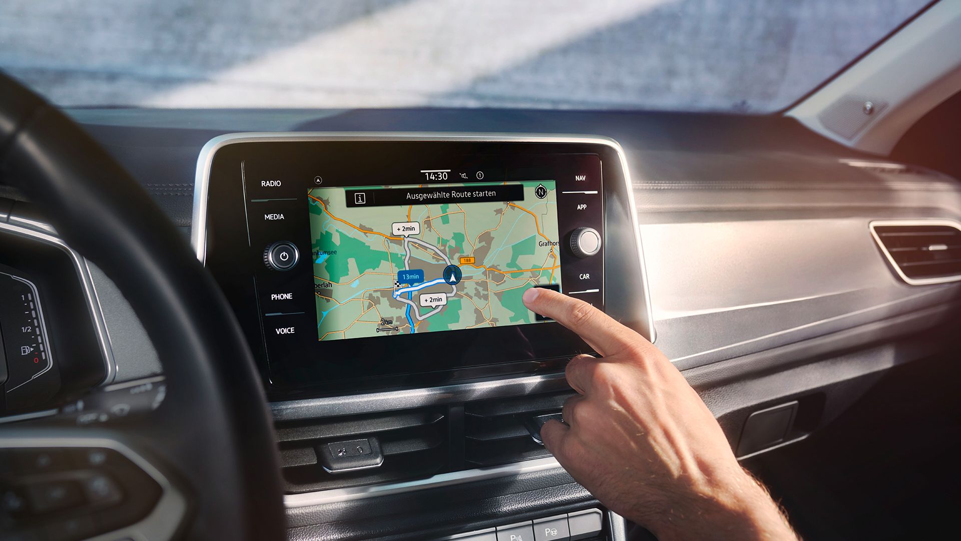 VW T-Roc Interieur, Detailansicht des Infotainment-Systems Discover Media, das gerade von einer Hand bedient wird
