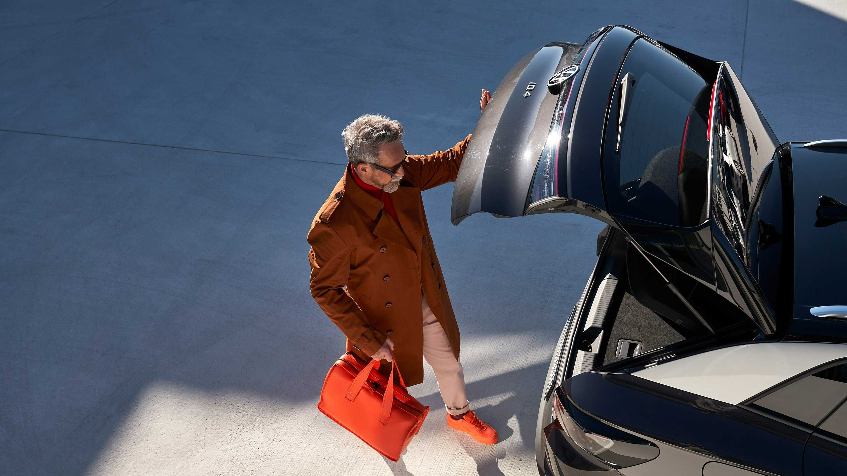 Ein Mann öffnet die Heckklappe eines Volkswagen ID.4