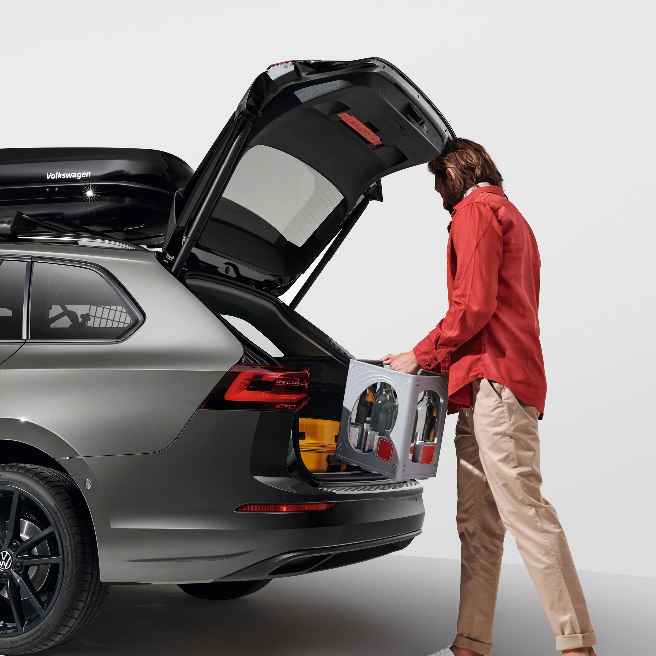 Ein Mann belädt den Kofferraum eines Volkswagen Golf Variant