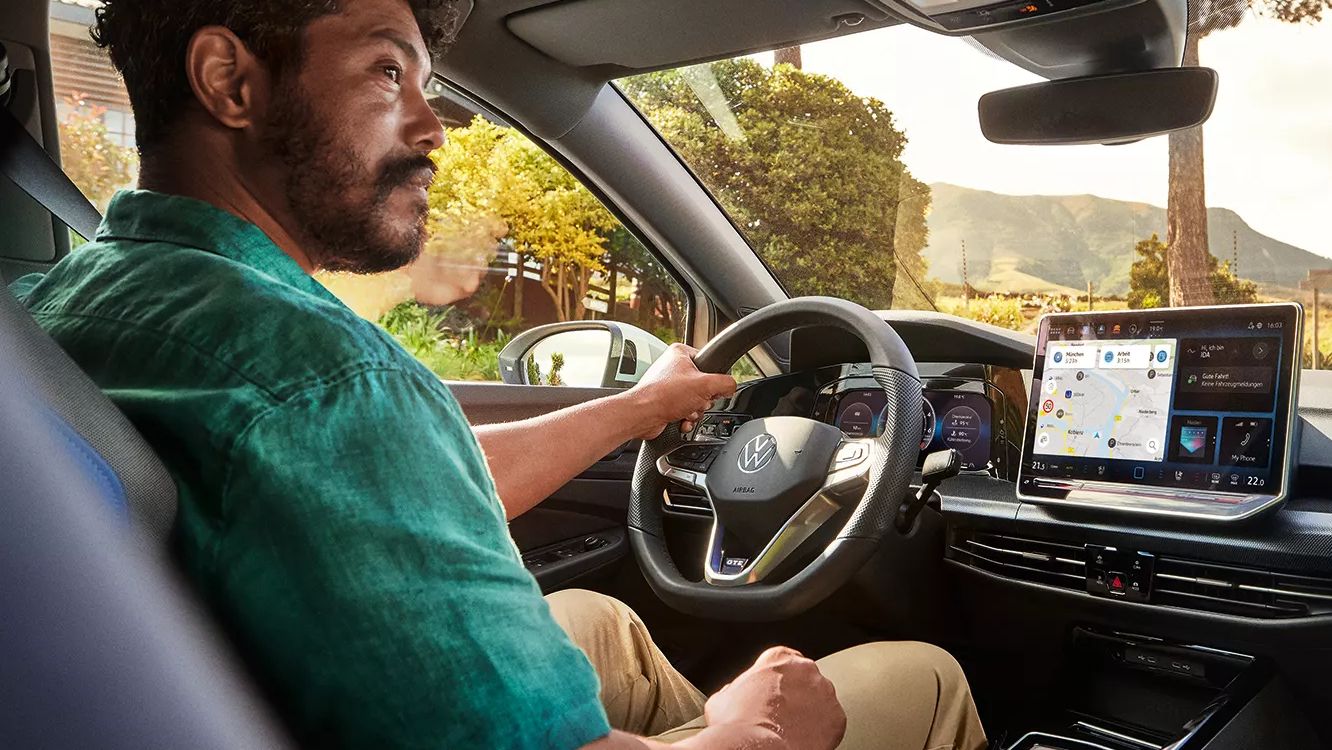 Mann sitzt am Steuer seines VW Golf GTE