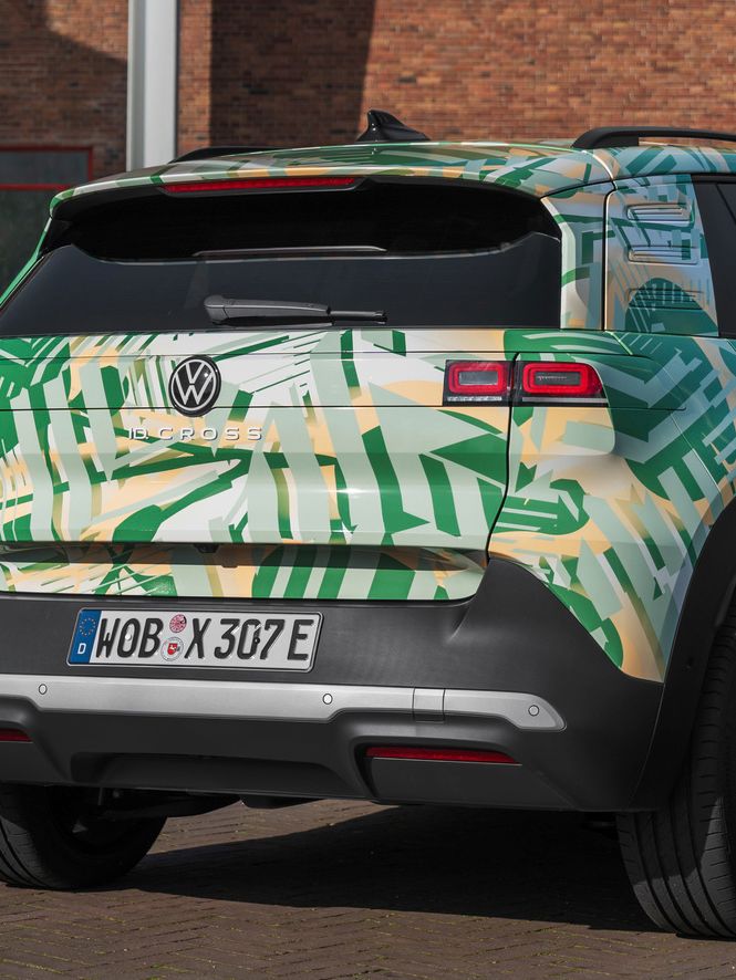 Ein Volkswagen SUV steht vor einem Backsteingebäude. Das Auto hat eine grüne und weiße Tarnlackierung und deutsche Kennzeichen. Es ist von hinten und leicht von der Seite zu sehen.