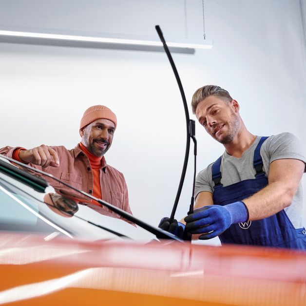 Ein VW Service Techniker wechselt Wischerblätter bei einem Volkswagen