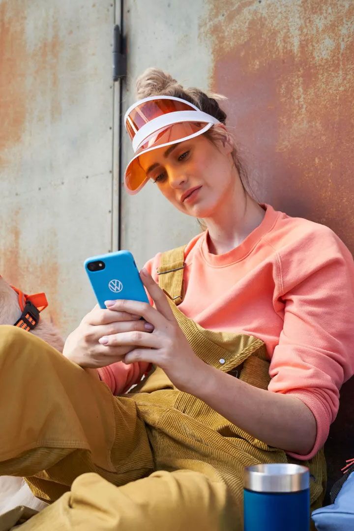 Eine Frau blickt auf ihr Smartphone, ein Hund ist bei ihr