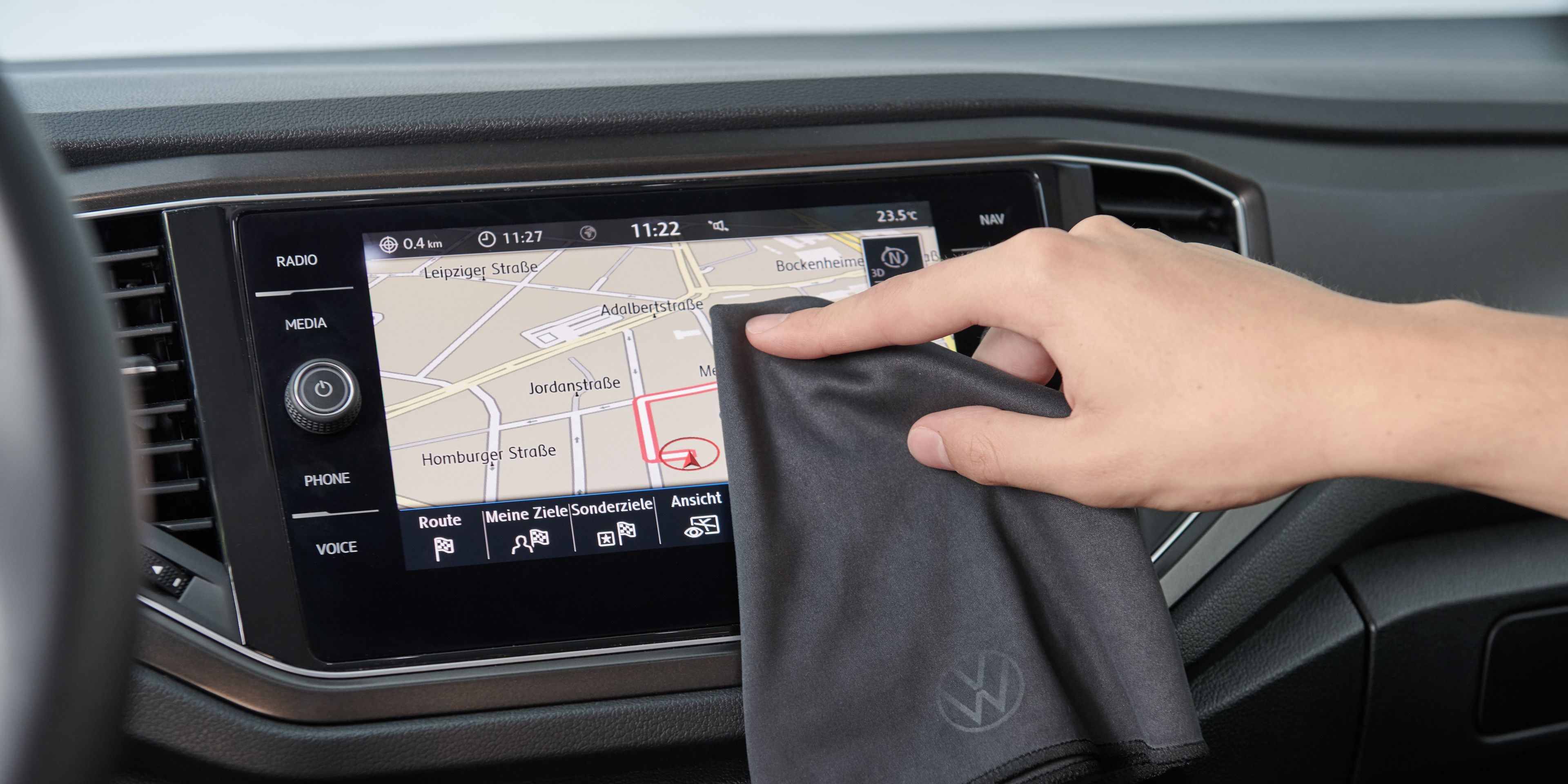 Das Display des Volkswagen Navis wird mit einem Volkswagen Reinigungstuch poliert