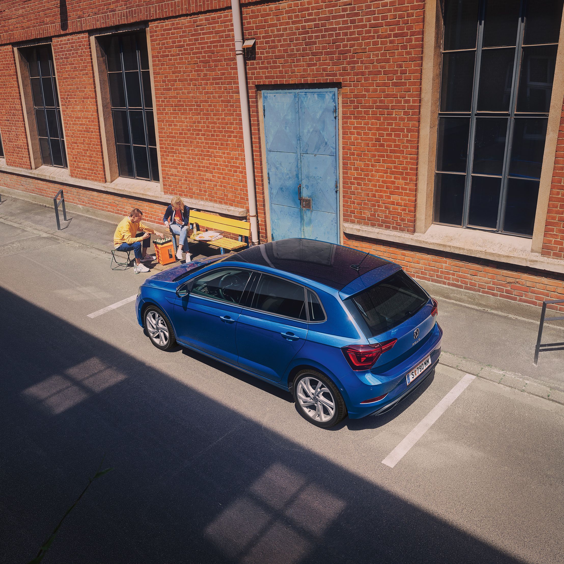Blick von oben auf einen blauen VW Polo R-Line der vor Industriegebäude geparkt ist
