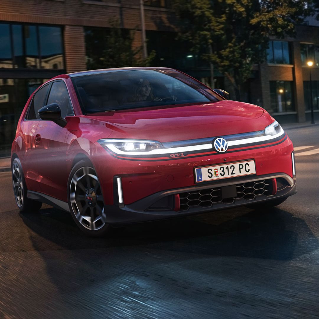 Ein roter VW ID. Polo GTI biegt bei abendlicher Stimmung in eine Straße ein.