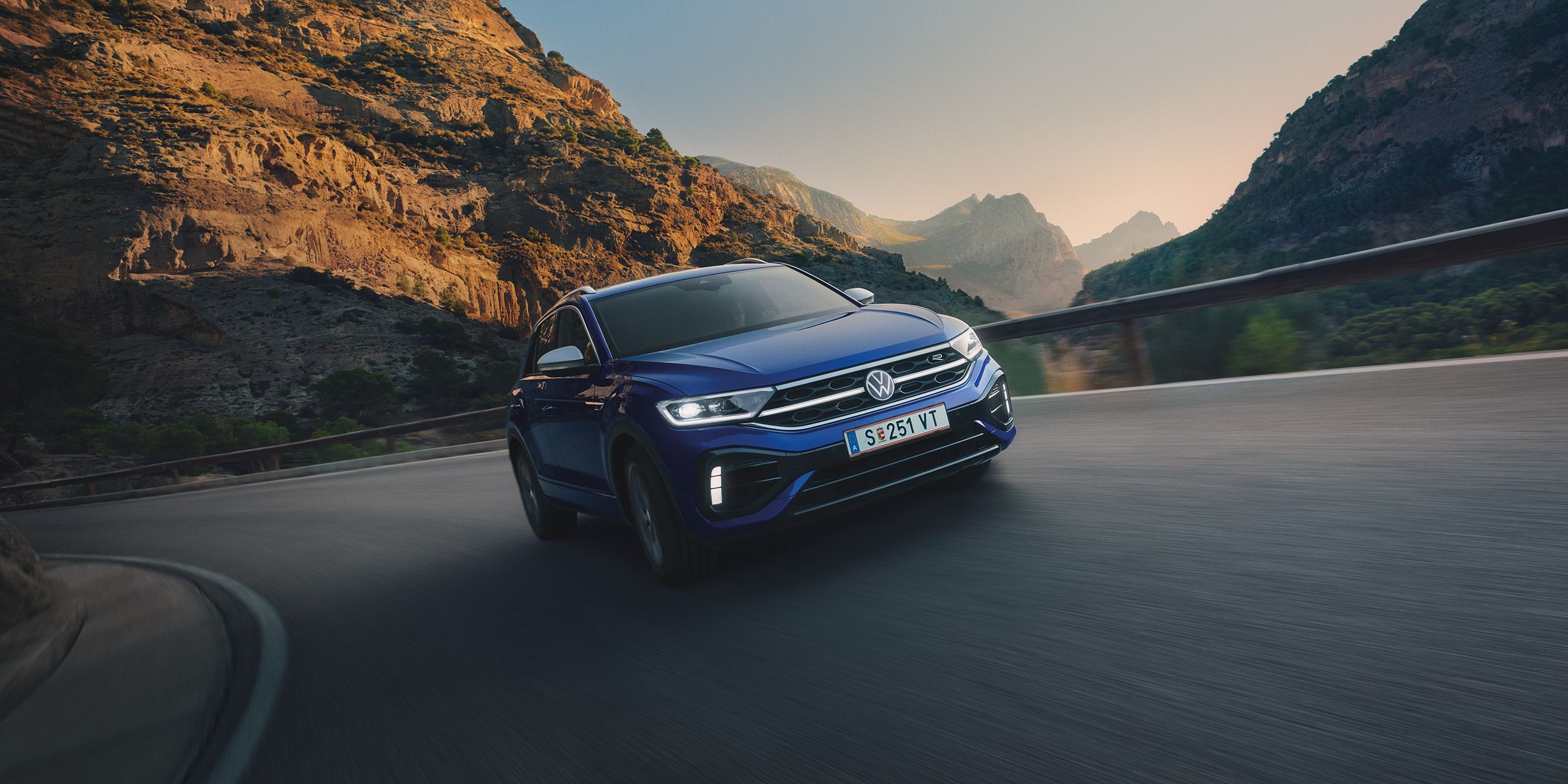 Der VW T-Roc fährt auf einer Bergstraße