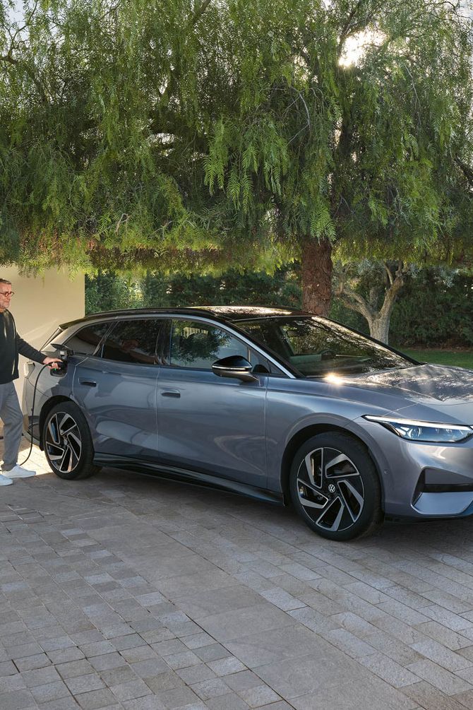 Mann lädt seinen VW ID.7 Tourer über eine Wallbox vor seiner Garage