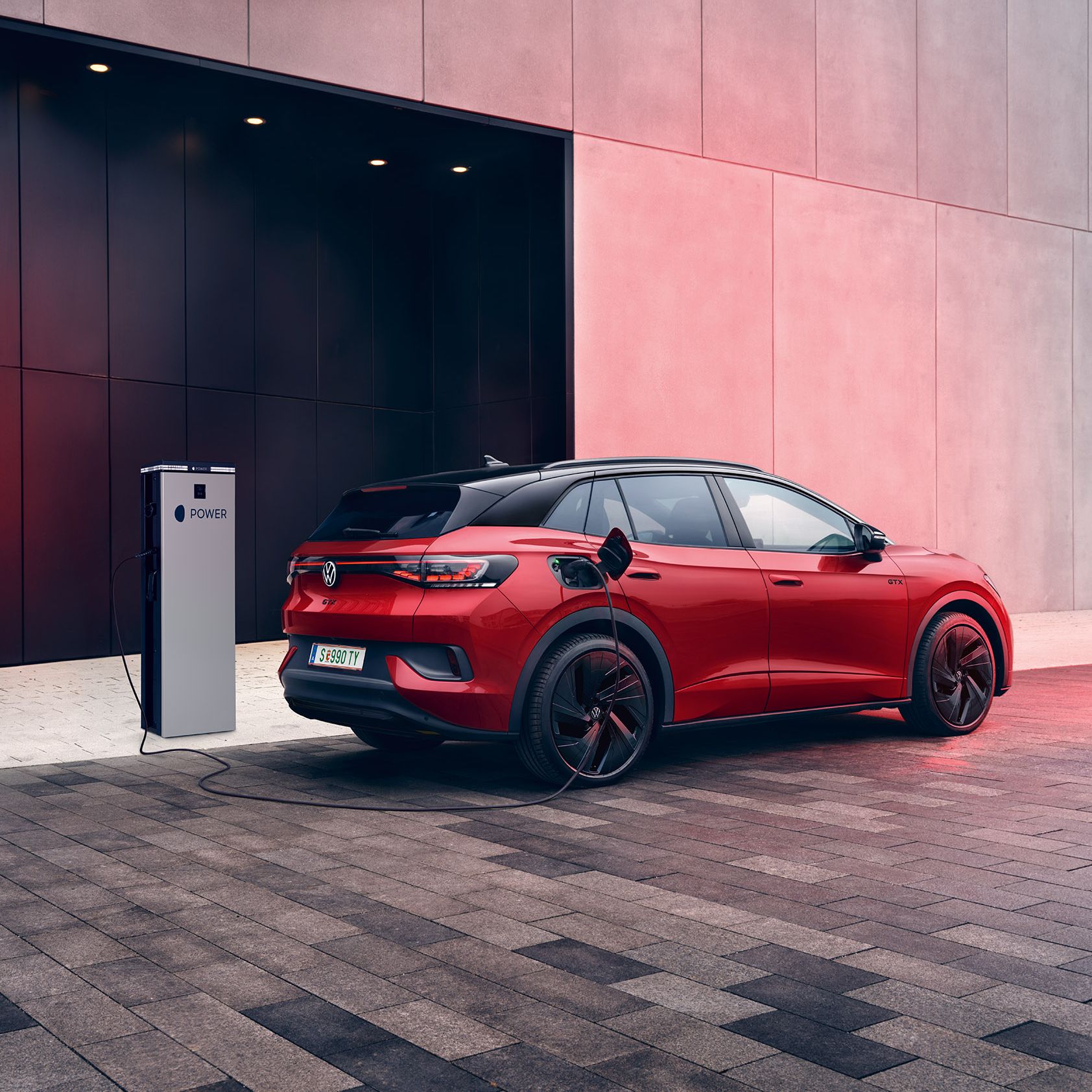 Heckansicht eines VW ID.4 GTX der gerade an MOON Ladestation geladen wird