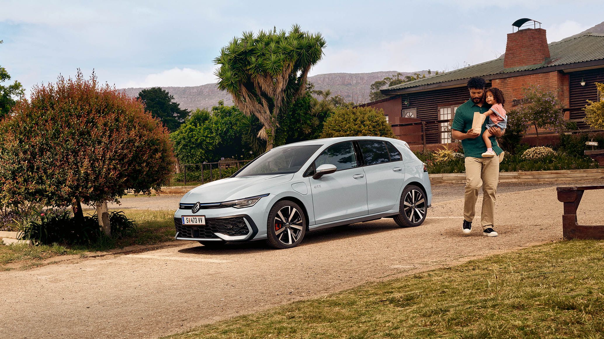 Der neue VW Golf GTE steht auf einem Parkplatz vor einem Haus.
