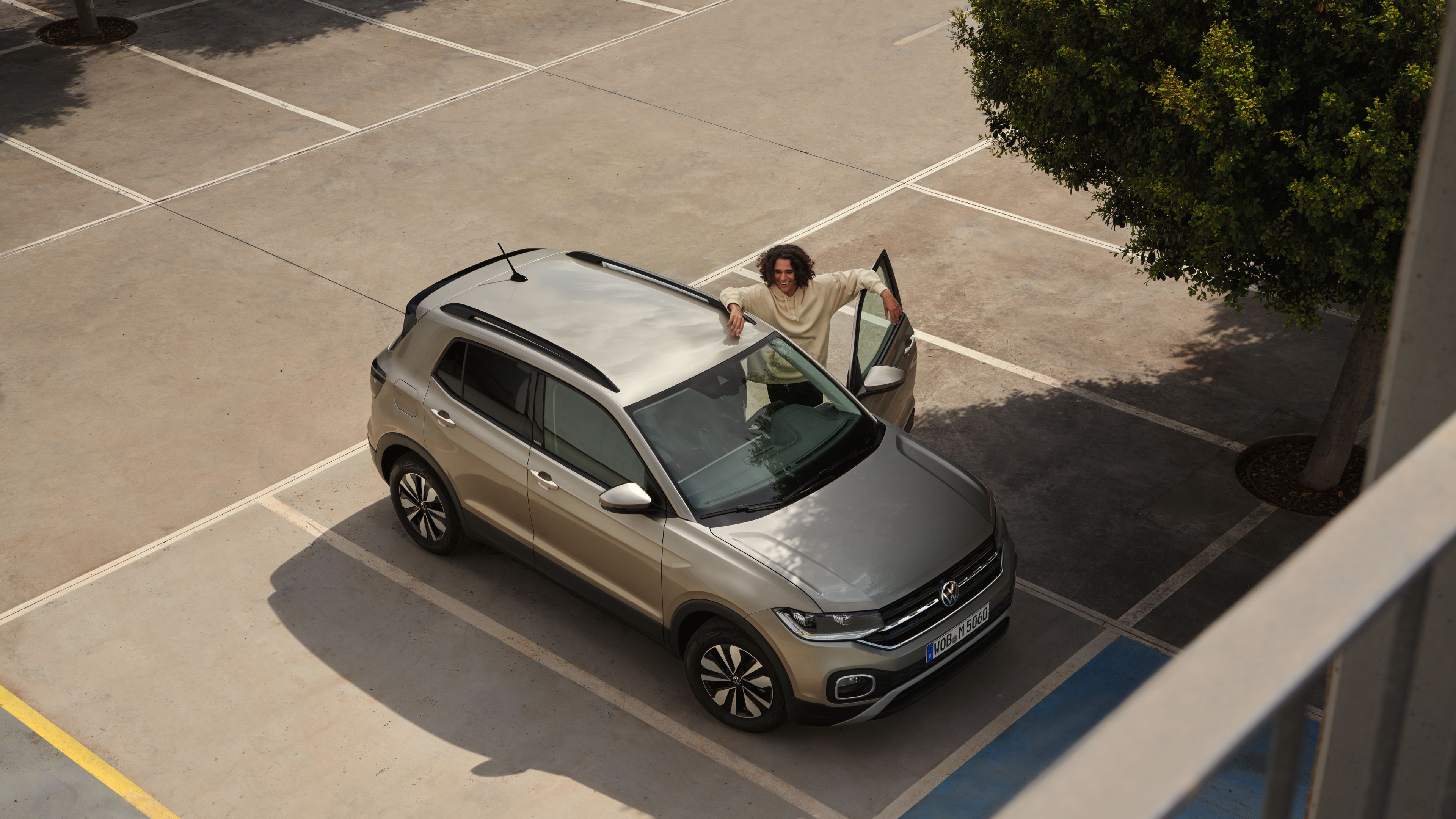 Mann steht an der geöffneten Fahrertür eines Volkswagen