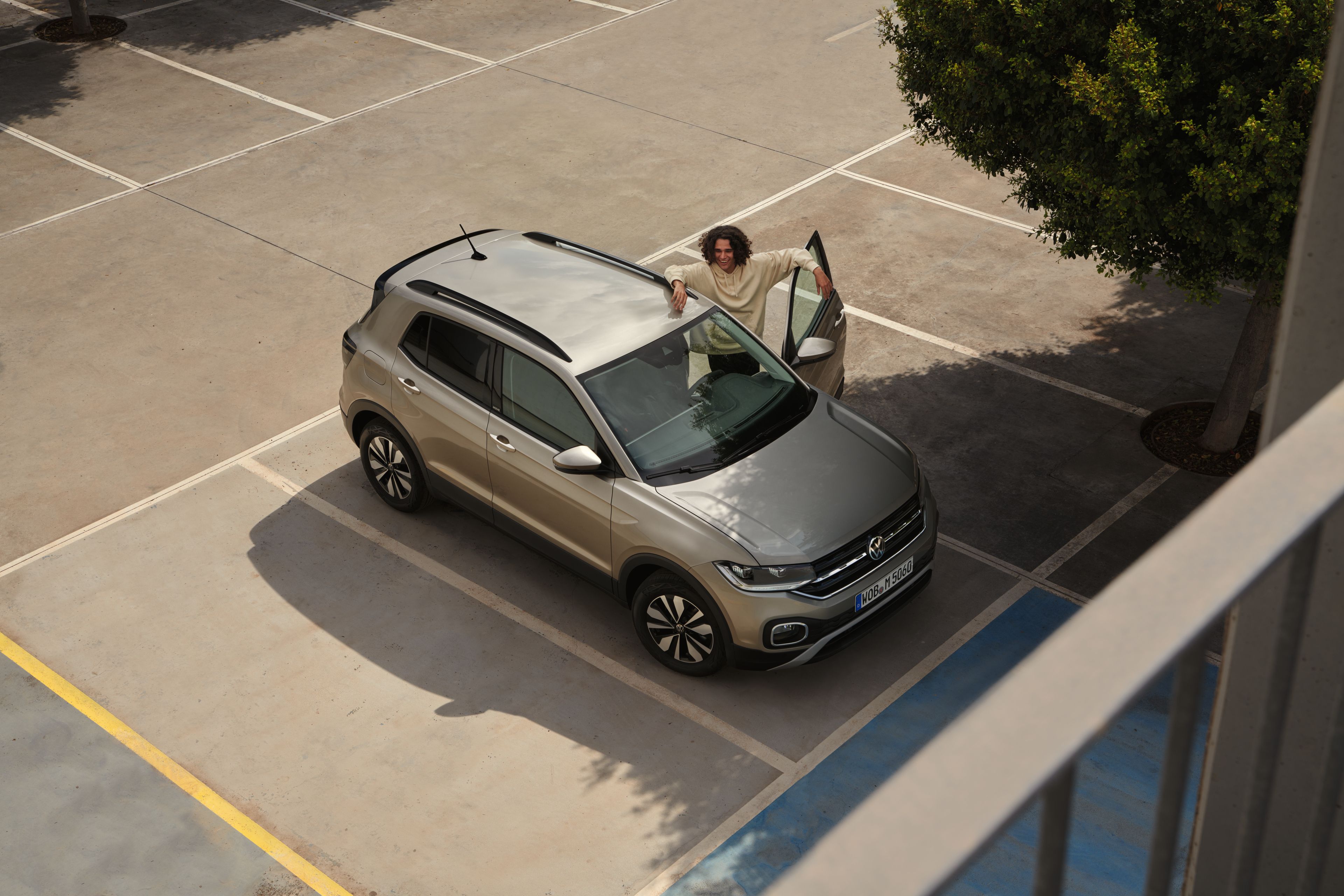 Mann steht an der geöffneten Fahrertür eines Volkswagen