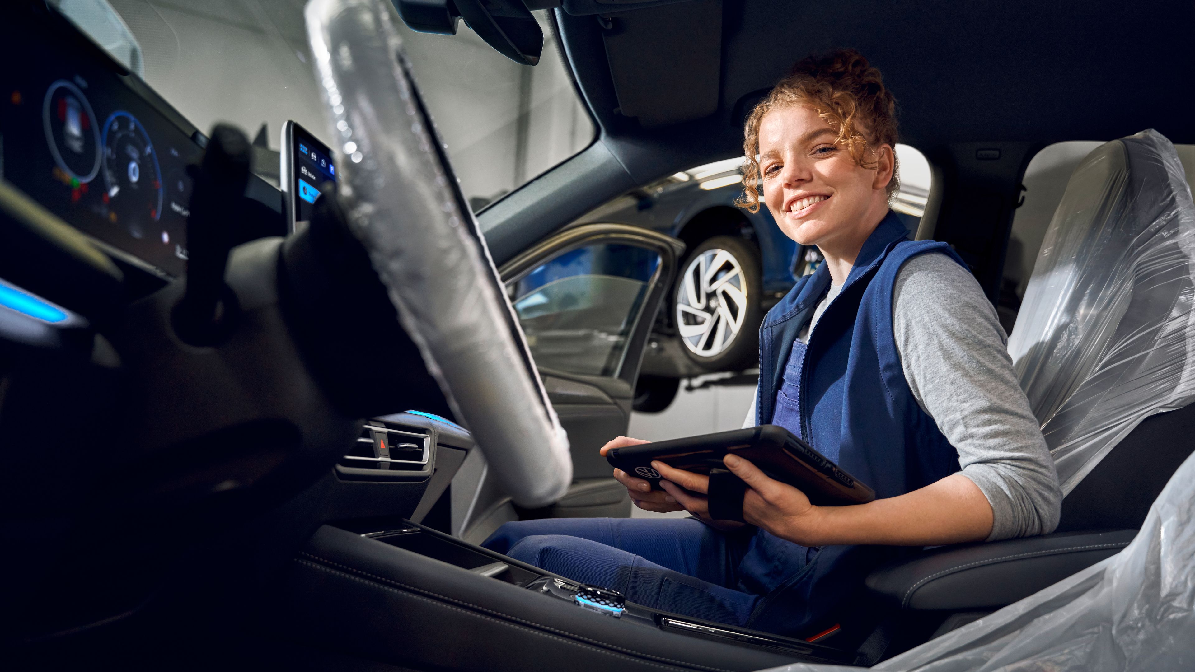 Eine Servicemitarbeiterin sitzt in einem VW