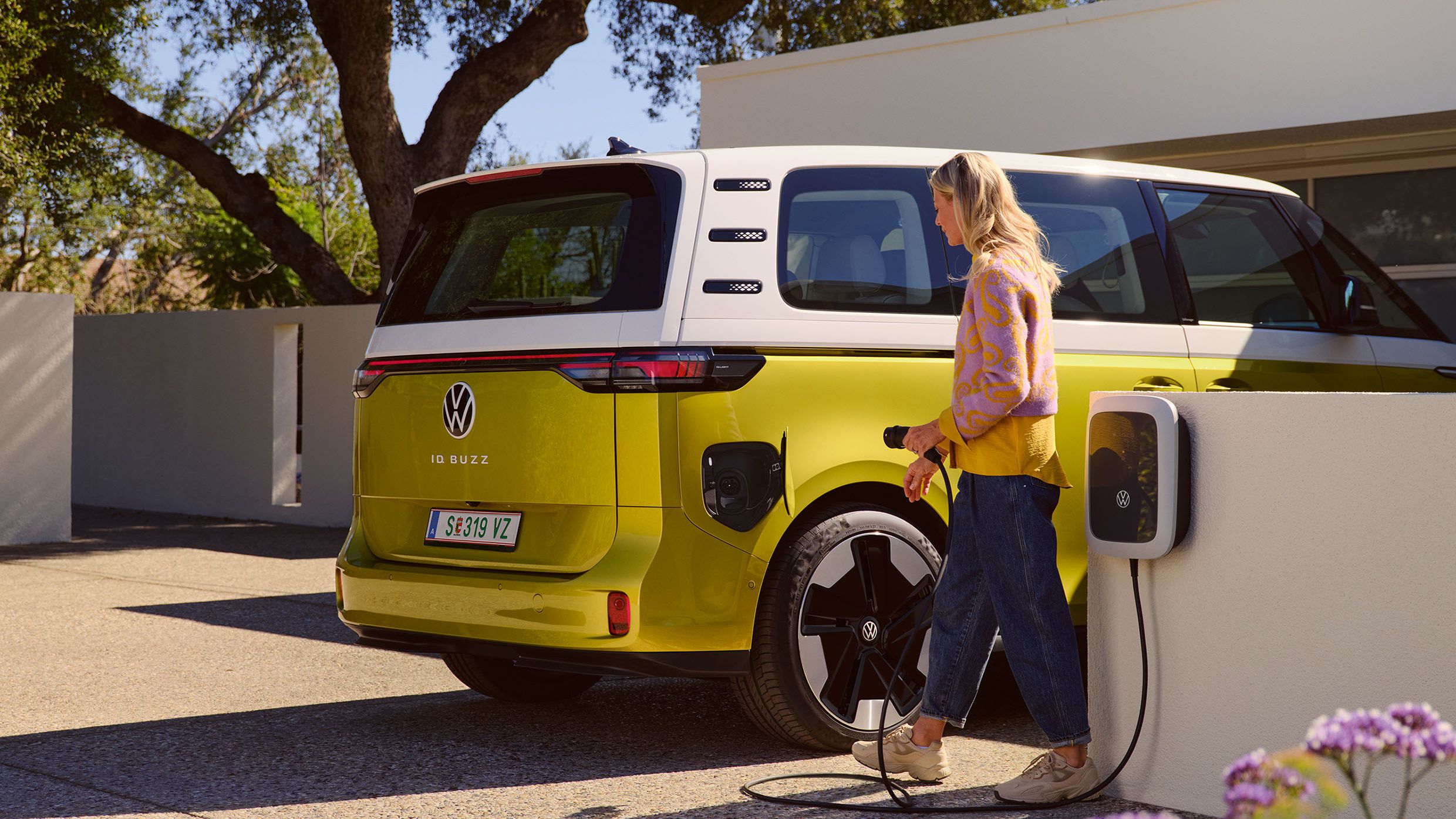 Eine Frau lädt den ID. Buzz einer Wallbox der Volkswagen Charging Group (Elli).
