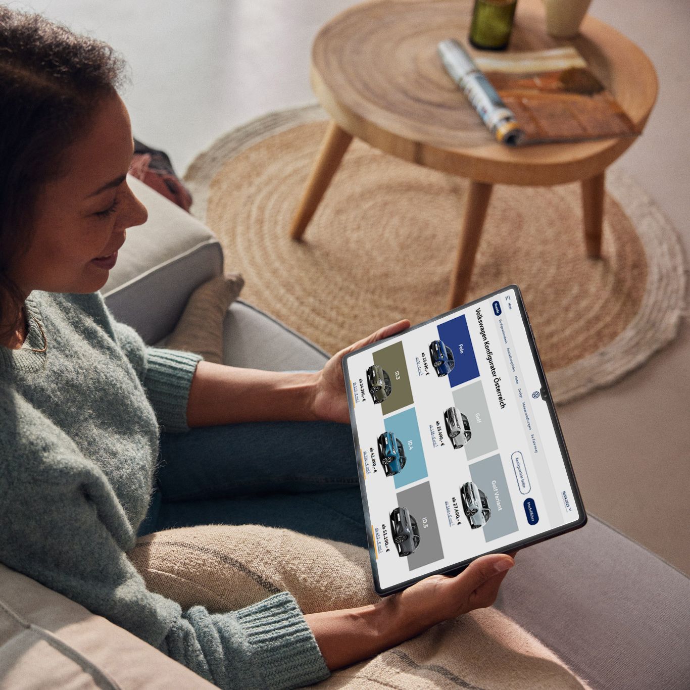 Eine Frau sieht sich die aktuellen VW Modelle auf ihrem Tablet an