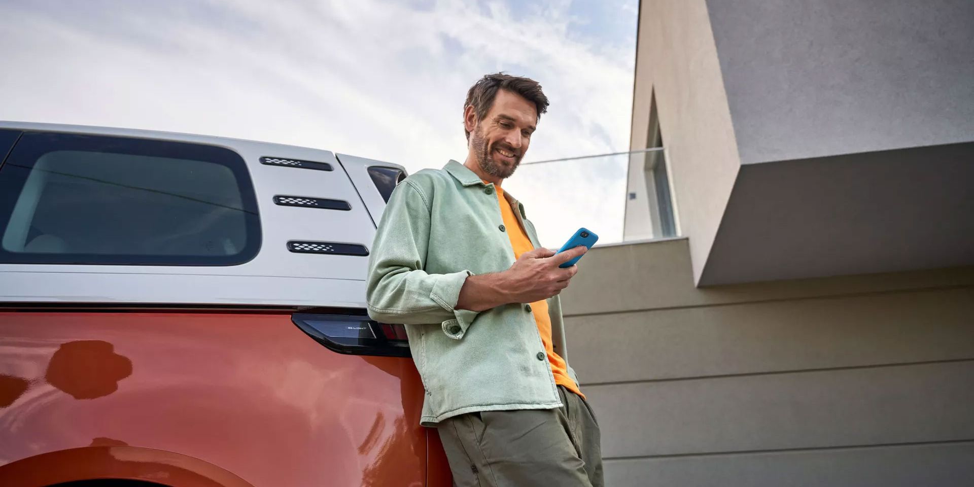 Im Mann mit Smartphone lehnt an einem ID. Buzz