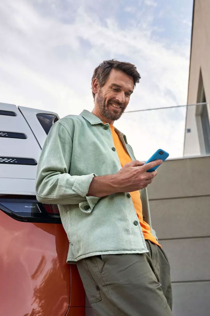 Im Mann mit Smartphone lehnt an einem ID. Buzz