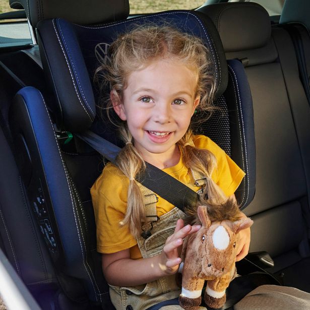 Ein Mädchen sitzt in einem Volkswagen Kindersitz